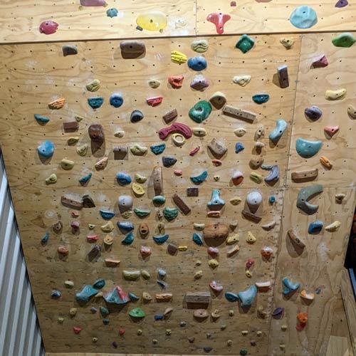 a variety of climbing holds on indoor climbing wall